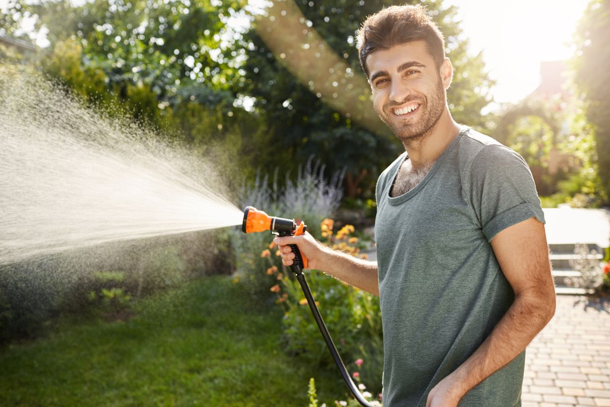 Mann gießt seinen Garten