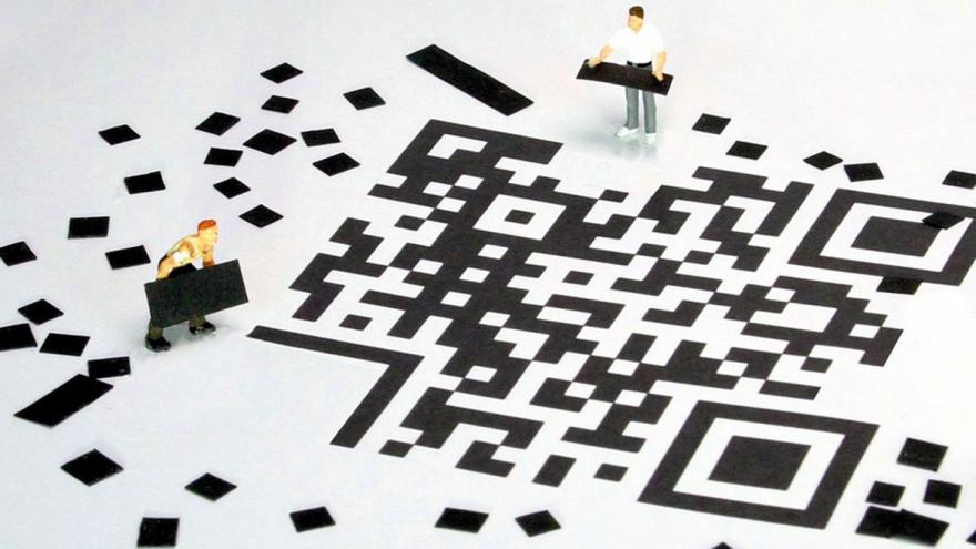 Miniaturfiguren bauen aus kleinen Papierschnipseln einen QR-Code