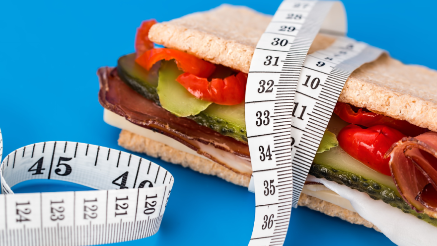 Dick belegtes Sandwich, von einem Maßband umwickelt