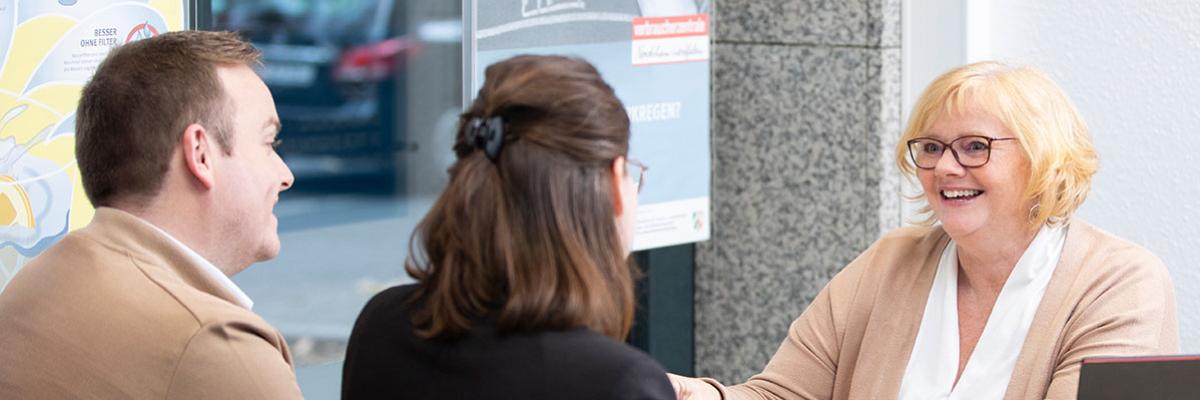 Beraterin mit zwei Ratsuchenden in einem Büro